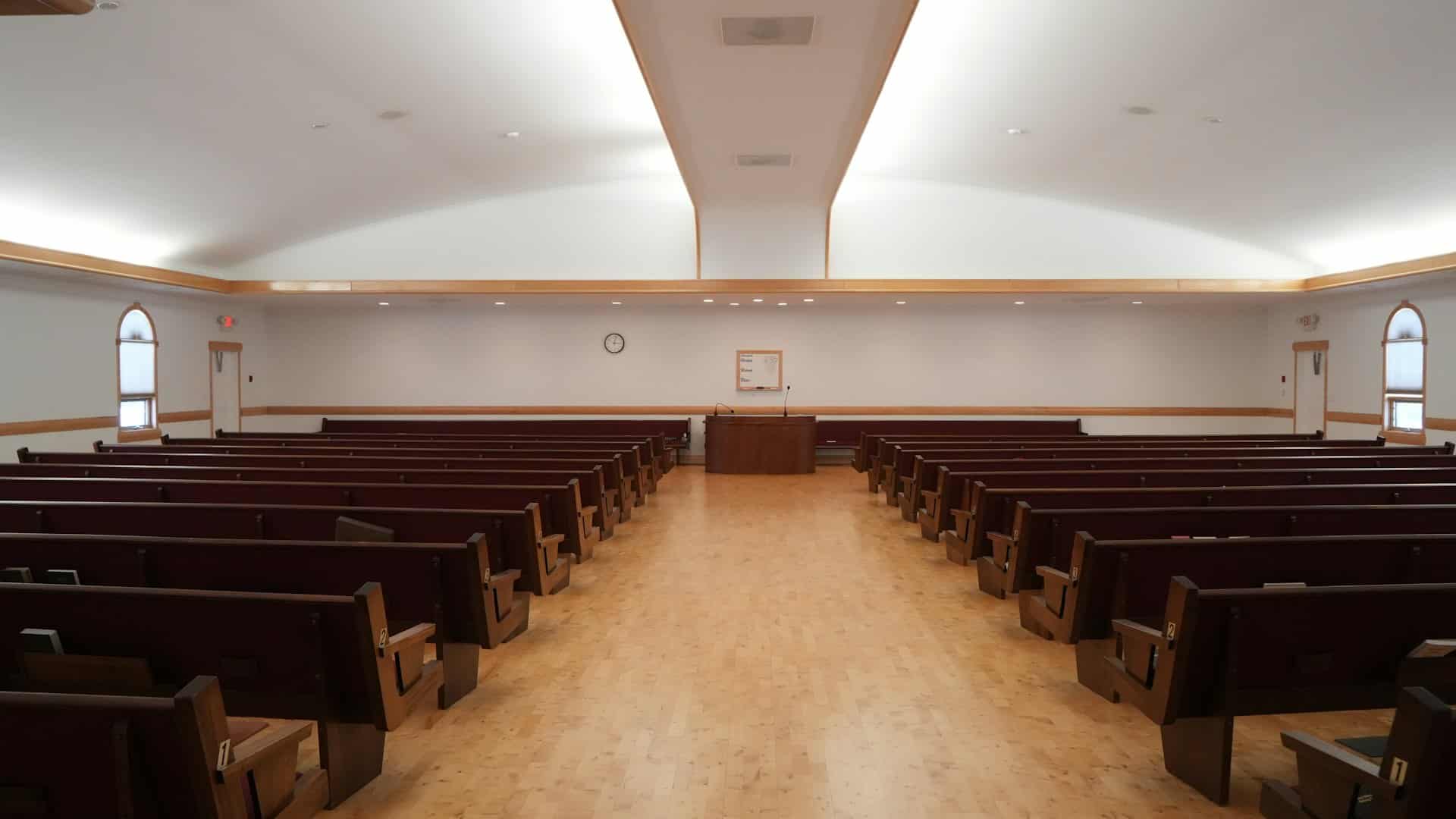 A bright church hall, with its pulpit and empty pews