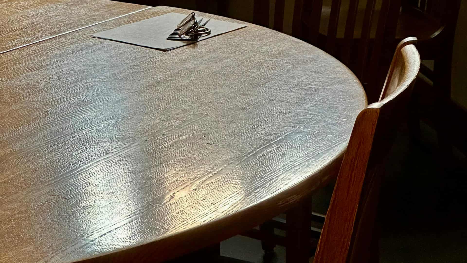 A wooden council table with a notepad on it